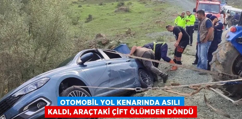 OTOMOBİL YOL KENARINDA ASILI KALDI, ARAÇTAKİ ÇİFT ÖLÜMDEN DÖNDÜ