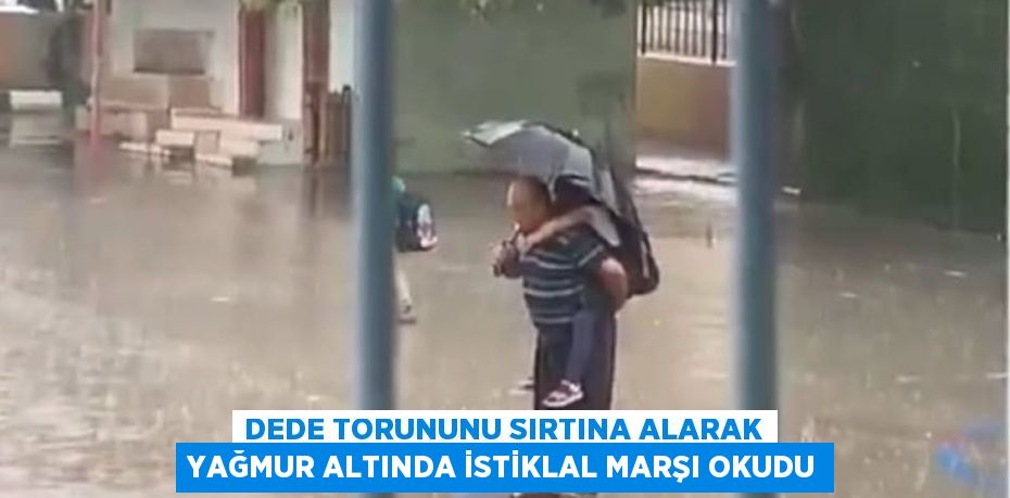 Dede torununu sırtına alarak yağmur altında İstiklal Marşı okudu