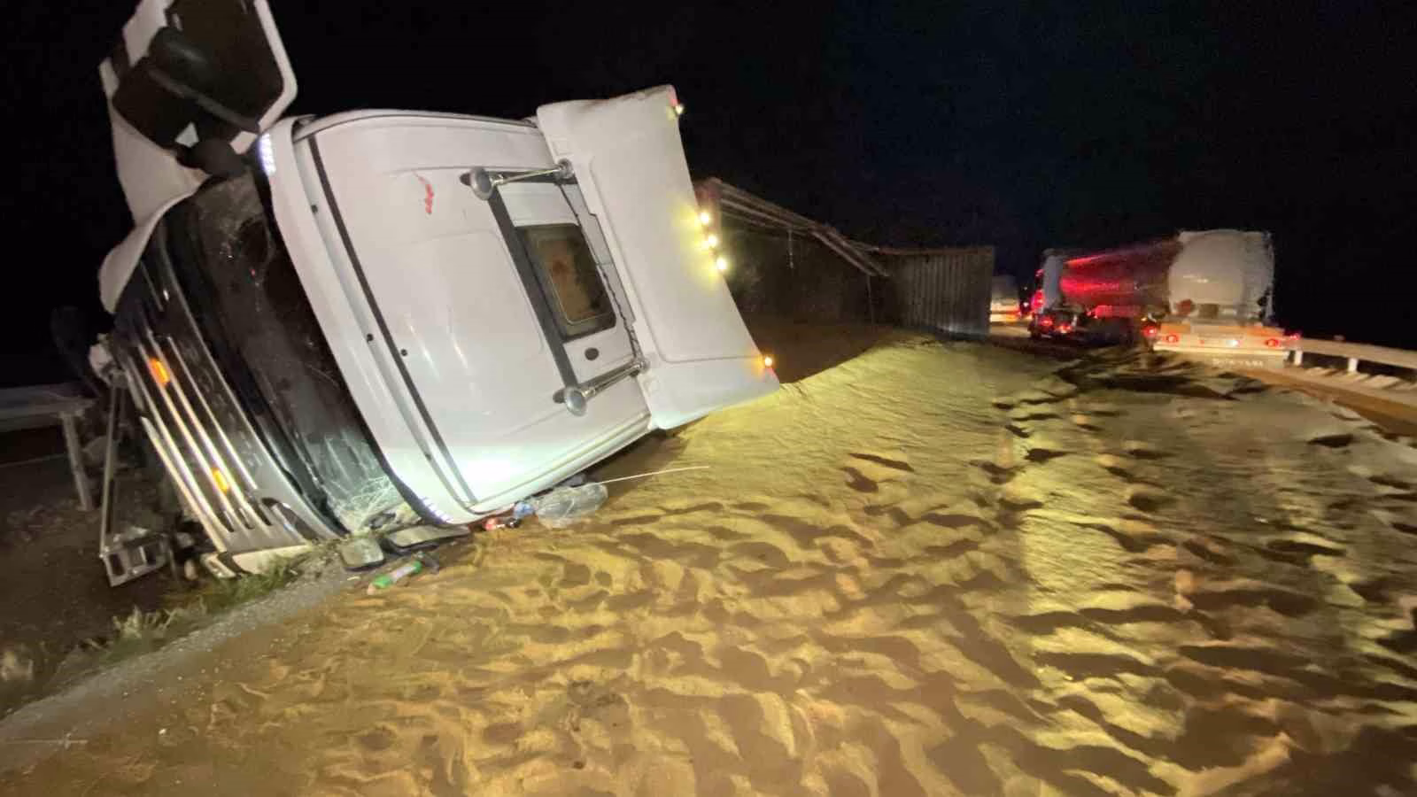 Tır devrildi, saçılan hayvan yemi yolu kapattı